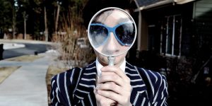 Man looking through magnify glass