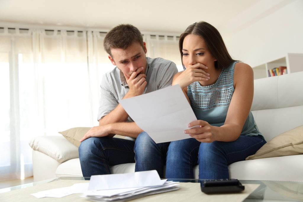 Worried young couple looking at bills